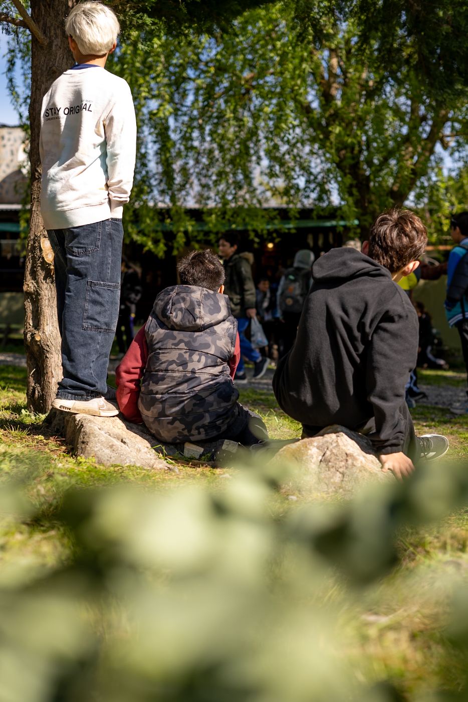 Chicos de un contingente escolar descansando bajo los árboles del parque de El Cazador